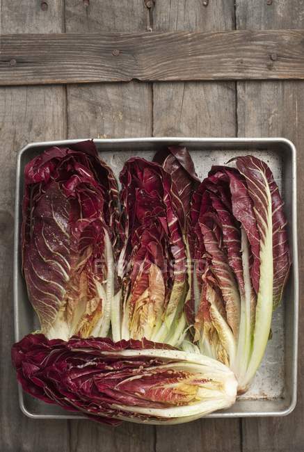 Top view of Treviso radicchio drizzled with oil, salt and pepper in tray — Stock Photo