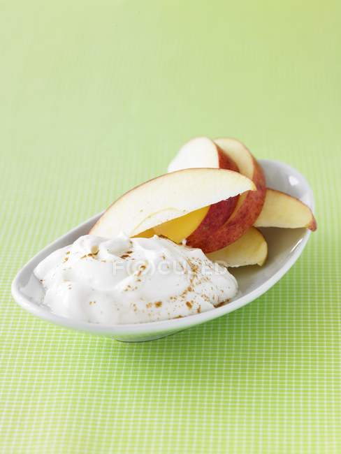 Primo piano vista di yogurt dolce con fette di mela e cannella cosparsa — Foto stock