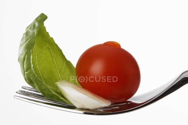 Tomate com mussarela e manjericão em garfo — Fotografia de Stock