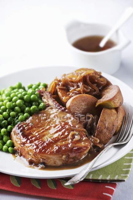 Pork chop with onions and peas — Stock Photo