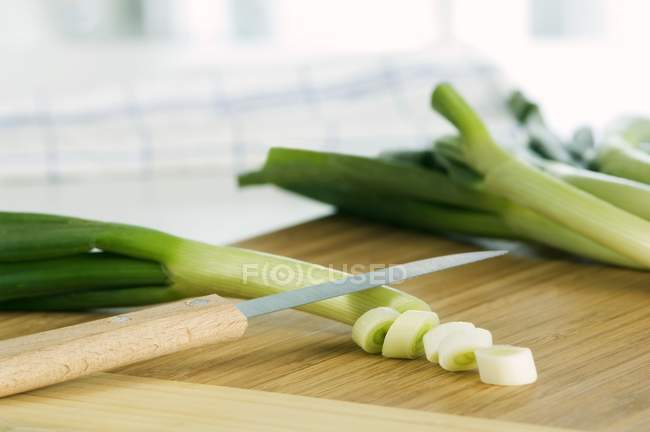 Spring onions being chopped — Stock Photo