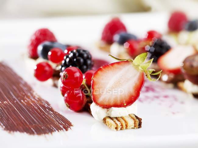 Fresh berries and slices of layer cake — Stock Photo