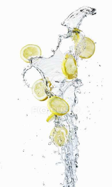 Лимонные ломтики в брызгах воды — стоковое фото