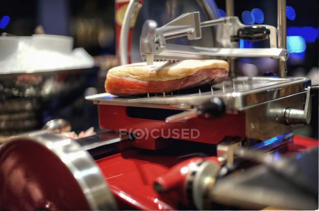 Vista close-up de presunto de Parma peça em uma máquina de corte — Fotografia de Stock