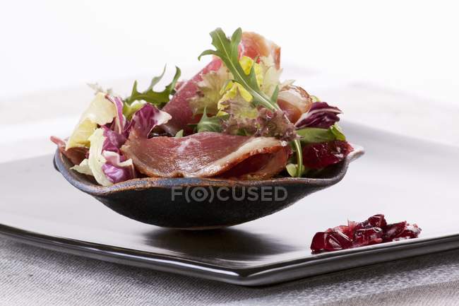 Closeup view of mixed leaf salad with smoked goose breast and dried cranberries — Stock Photo
