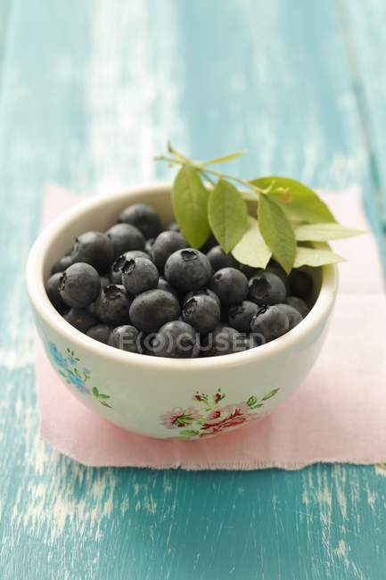Blueberries and leaves in rustic bowl — Stock Photo