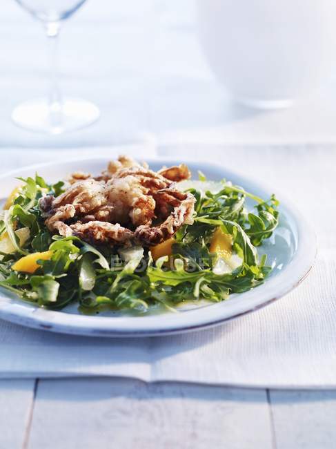 Fried crab on bed of rocket salad — Stock Photo