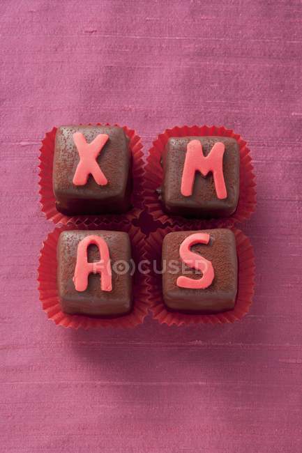 Pralines decorated with letters — Stock Photo