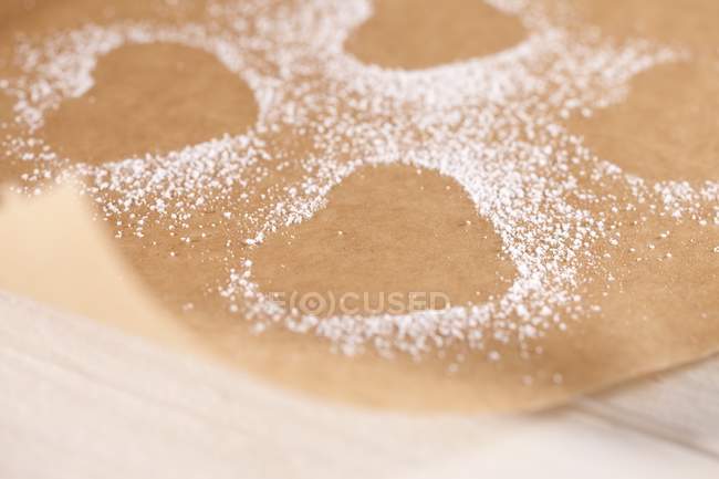 Vue rapprochée des empreintes en forme de coeur dans le sucre glace sur parchemin — Photo de stock