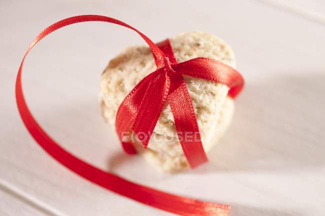Biscoito em forma de coração amarrado com fita vermelha — Fotografia de Stock