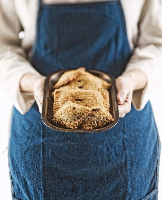 Primer plano vista recortada de la persona sosteniendo pequeño plato de metal de tartas de mora - foto de stock