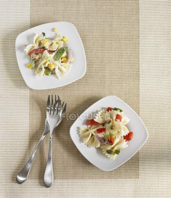 Две тарелки курицы и салат из макарон — стоковое фото