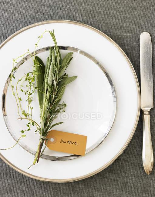 Top view of place setting with a bouquet of herbs and a name tag — Stock Photo