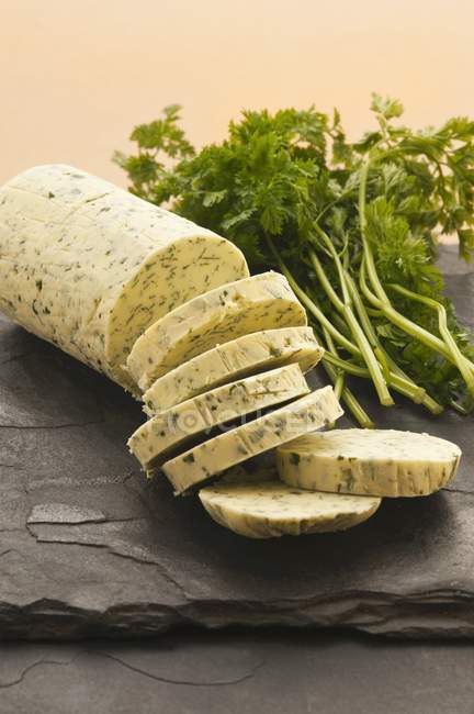 Closeup view of a sliced roll of herbal butter — Stock Photo