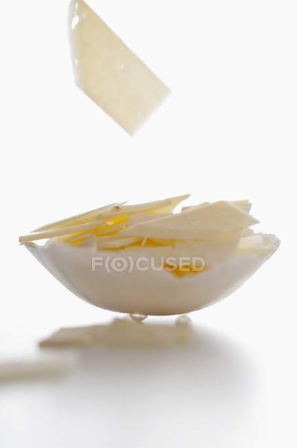 Slices of cheese falling into bowl — Stock Photo