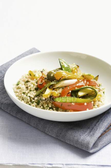 Quinoa mit buntem Gemüse auf weißem Teller über Handtuch — Stockfoto