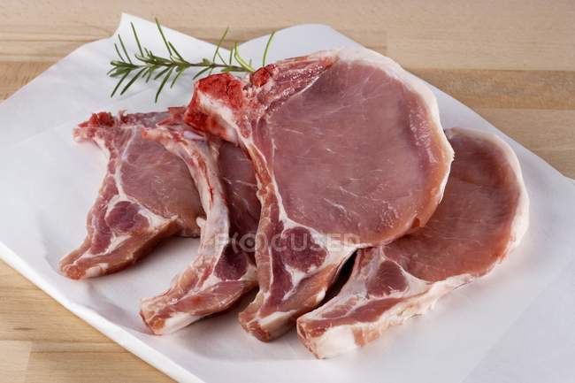 Chuleta de cerdo cruda en papel de carnicero - foto de stock
