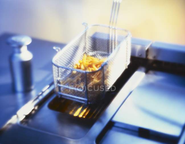 Despejar batatas fritas no interior da cozinha — Fotografia de Stock