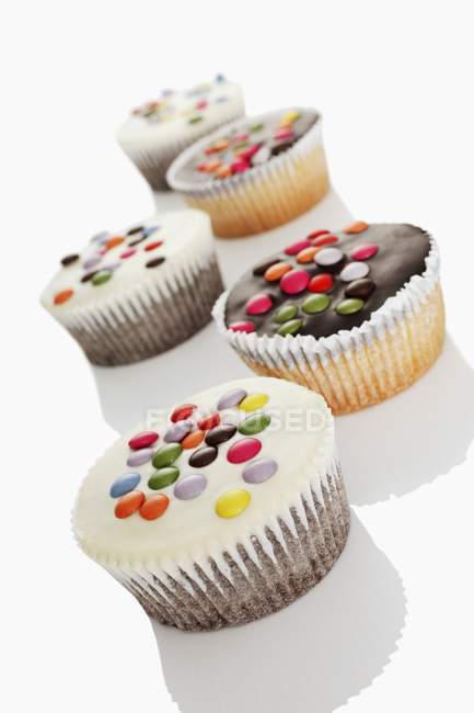 Кексы украшены цветными шоколадными бобами — стоковое фото