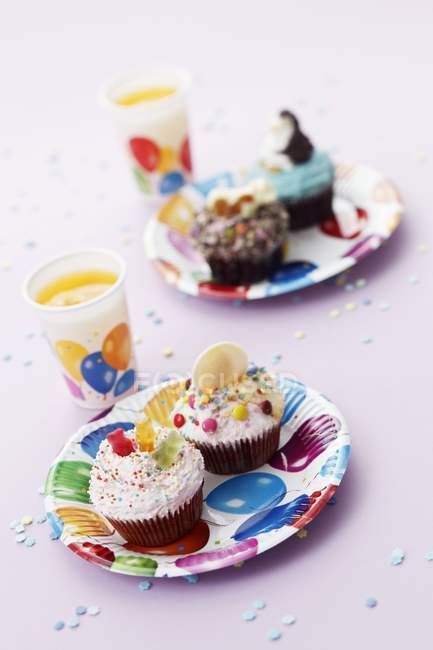Colorful cupcakes and orange juice — Stock Photo