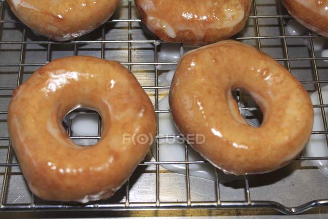 Donuts acristalados en un estante de enfriamiento - foto de stock