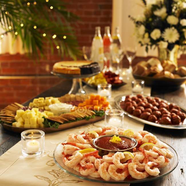 Vista elevada del plato de camarones en la mesa con una variedad de platos - foto de stock