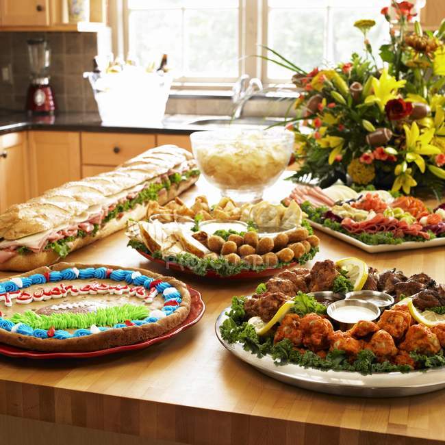 Дневной вид на различные блюда с цветами на кухонном столе — стоковое фото