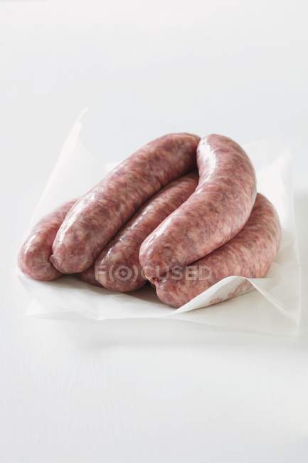 Raw Sausages on paper — Stock Photo