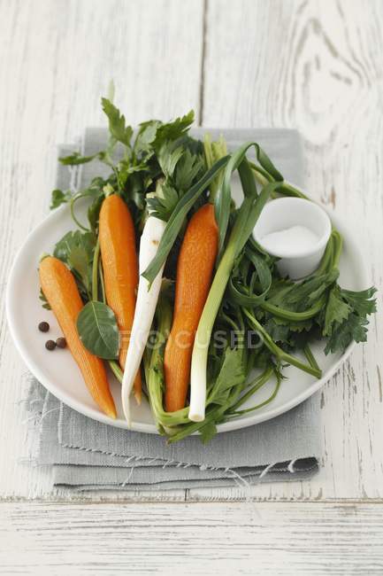 Суп овощи и специи на белой тарелке над полотенцем — стоковое фото