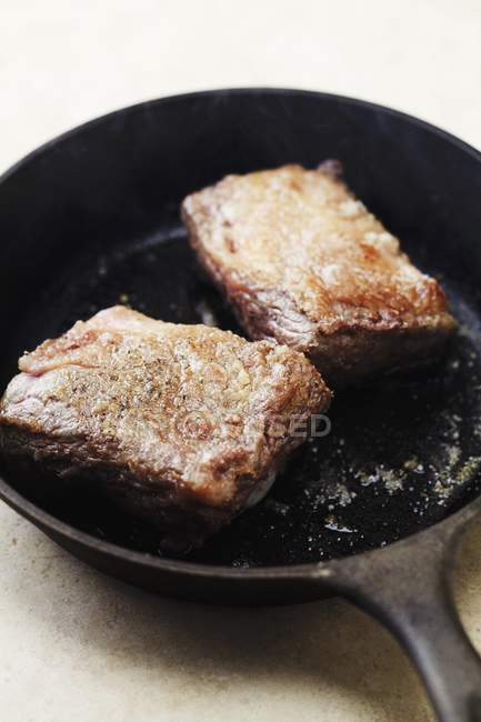 Смажена ребра яловичини в сковороду — стокове фото