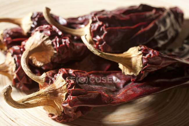 Dried Whole Guajillo Chilies on wooden surface — Stock Photo