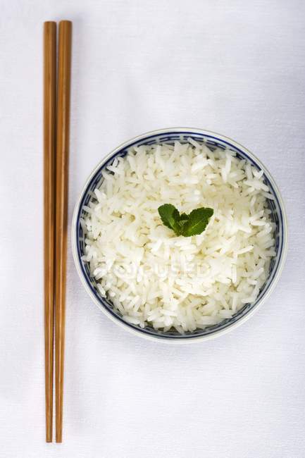 Chopsticks and bowl of rice — Stock Photo