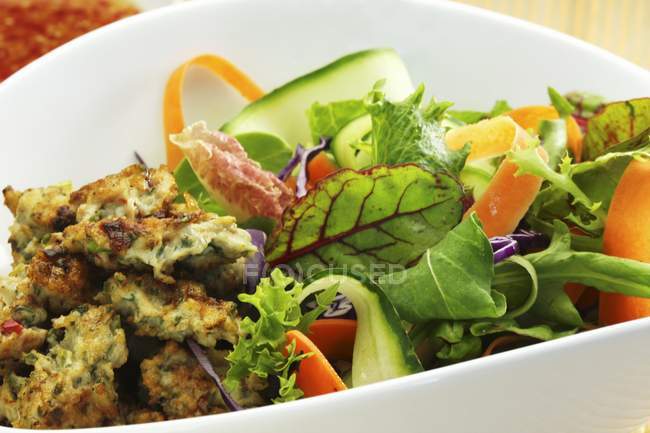Closeup view of salad with vegetables and deep-fried chicken — Stock Photo