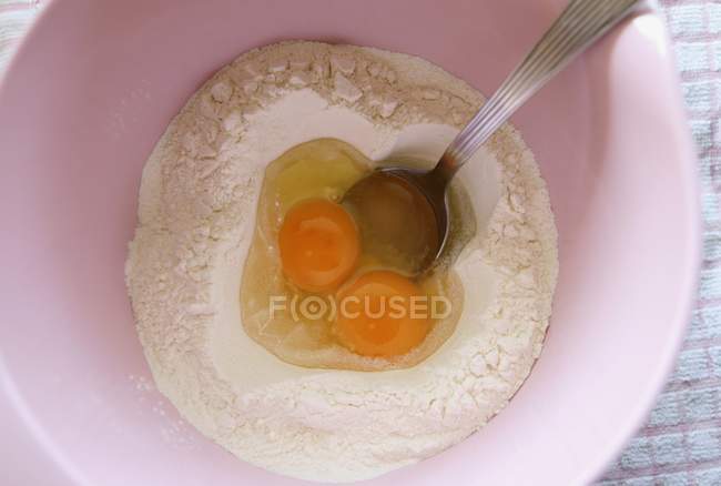 Raw Eggs and flour in bowl — Stock Photo
