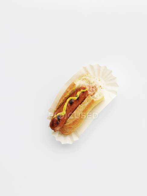 Cachorro-quente com mostarda em placa de papel — Fotografia de Stock