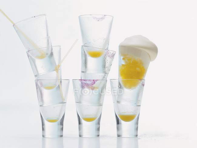 Closeup view of orange shot with cream and piles of glasses — Stock Photo
