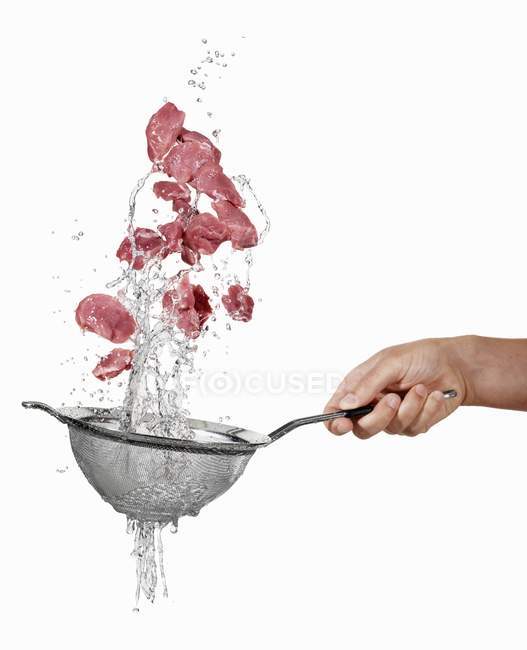 Human hand washing Pork in sieve — Stock Photo