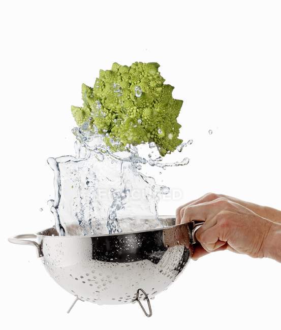 Lavado de brócoli Romanesco en colador - foto de stock