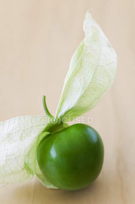 Tomatillo avec écorce pelée Retour sur la surface en bois — Photo de stock