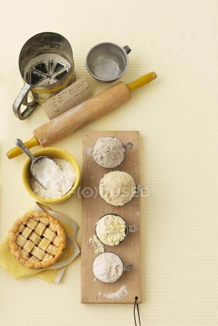 Vue du dessus de la farine avec rouleau à pâtisserie, tamis et tartelette — Photo de stock
