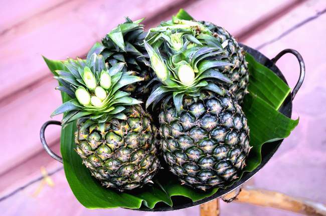 Fresh pineapples on banana leaves — Stock Photo
