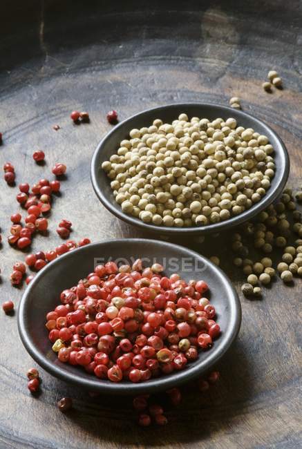 Grãos de pimenta vermelha e branca em taças — Fotografia de Stock