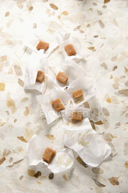 Вид сверху на масляные карамельные сладости и обертки — стоковое фото