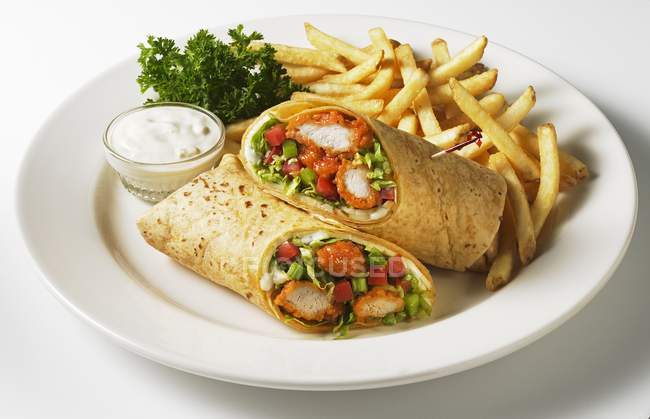 Closeup view of buffalo chicken salad wraps with french fries on white plate — Stock Photo
