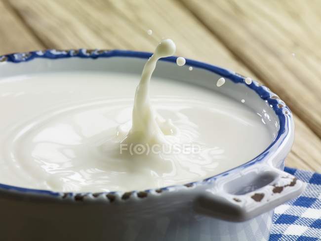 Milk splashing out of a bowl — Stock Photo
