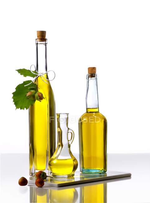 Vista de cerca de tres botellas de aceite de avellana - foto de stock