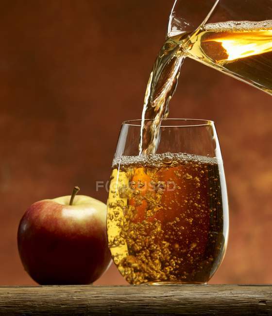 Наливание яблочного сока — стоковое фото