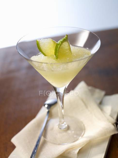 Closeup view of frozen Daiquiri cocktail with lime slices — Stock Photo