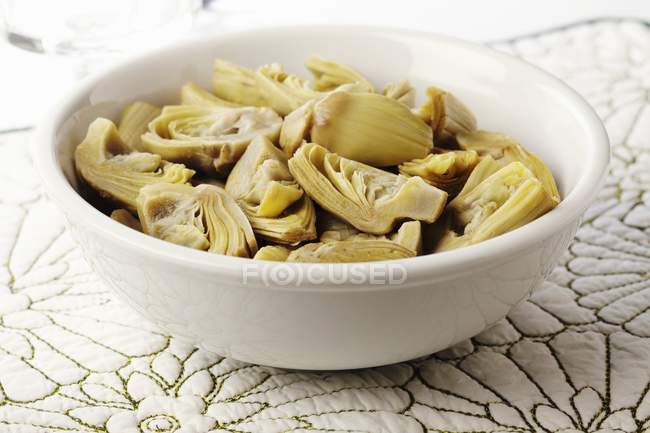 A Bowl of Quartered Artichoke Hearts over table — Stock Photo