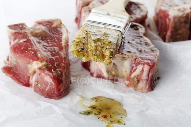 Côtelettes d'agneau crues avec brosse et marinade — Photo de stock
